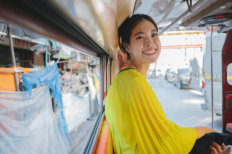 亚洲年轻人在泰国清迈旅游乘出租车(Rod dang或红色出租车)泰国清迈当地的公共交通工具